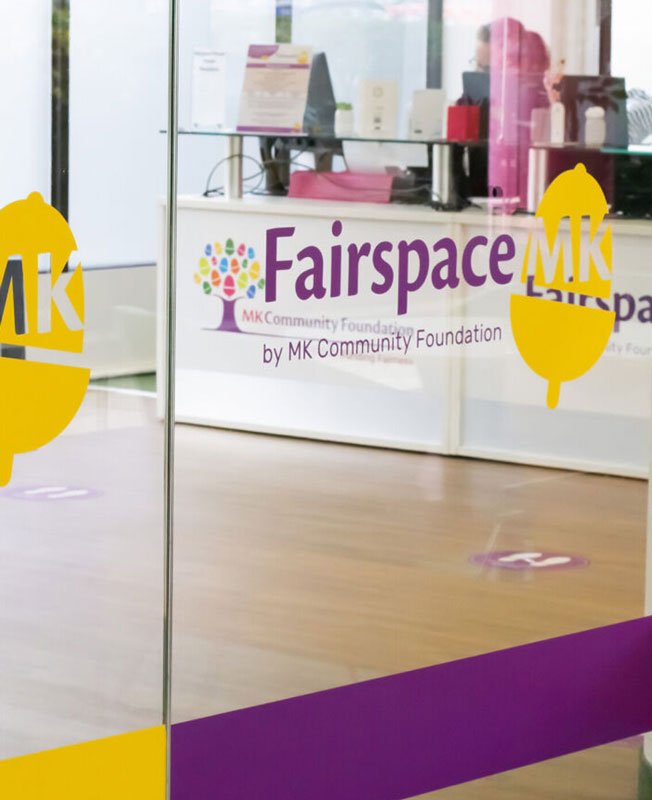 an interior glass panel with fairspace MK logo decals applied in purple and yellow