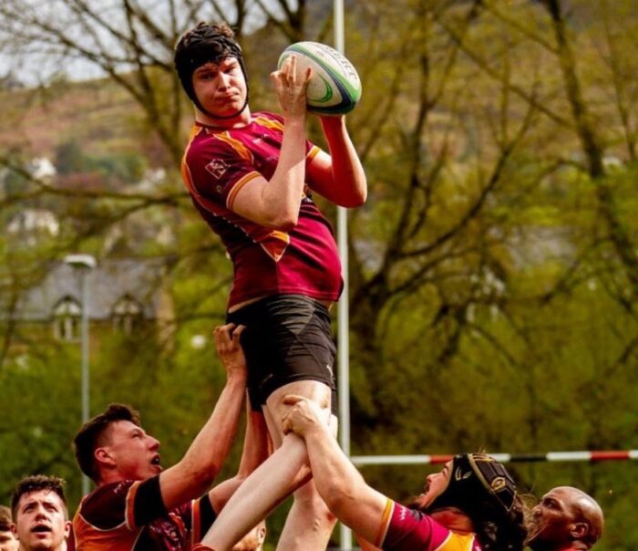 an image of a rugby player being lifted by his team mates to catch the ball