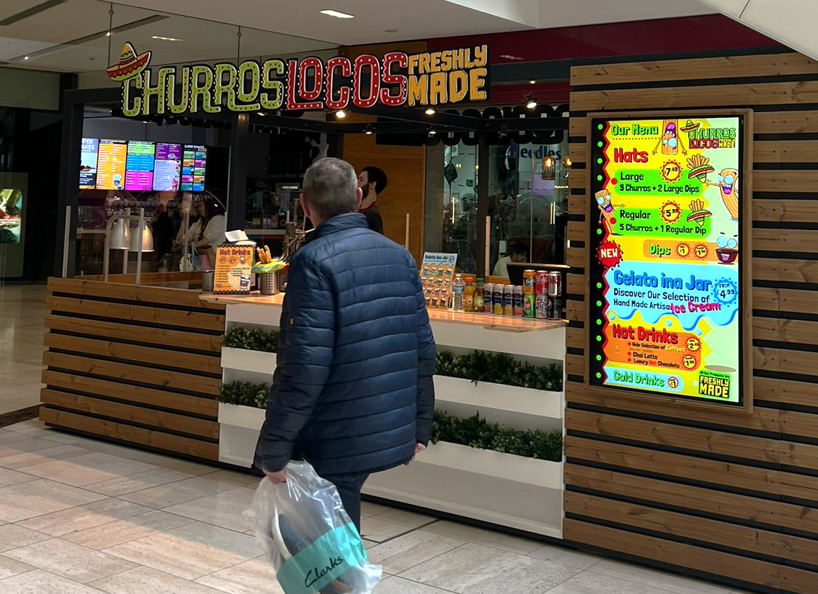 a bold design of a churros kiosk with detailed signage and a bright menu shown on a screen